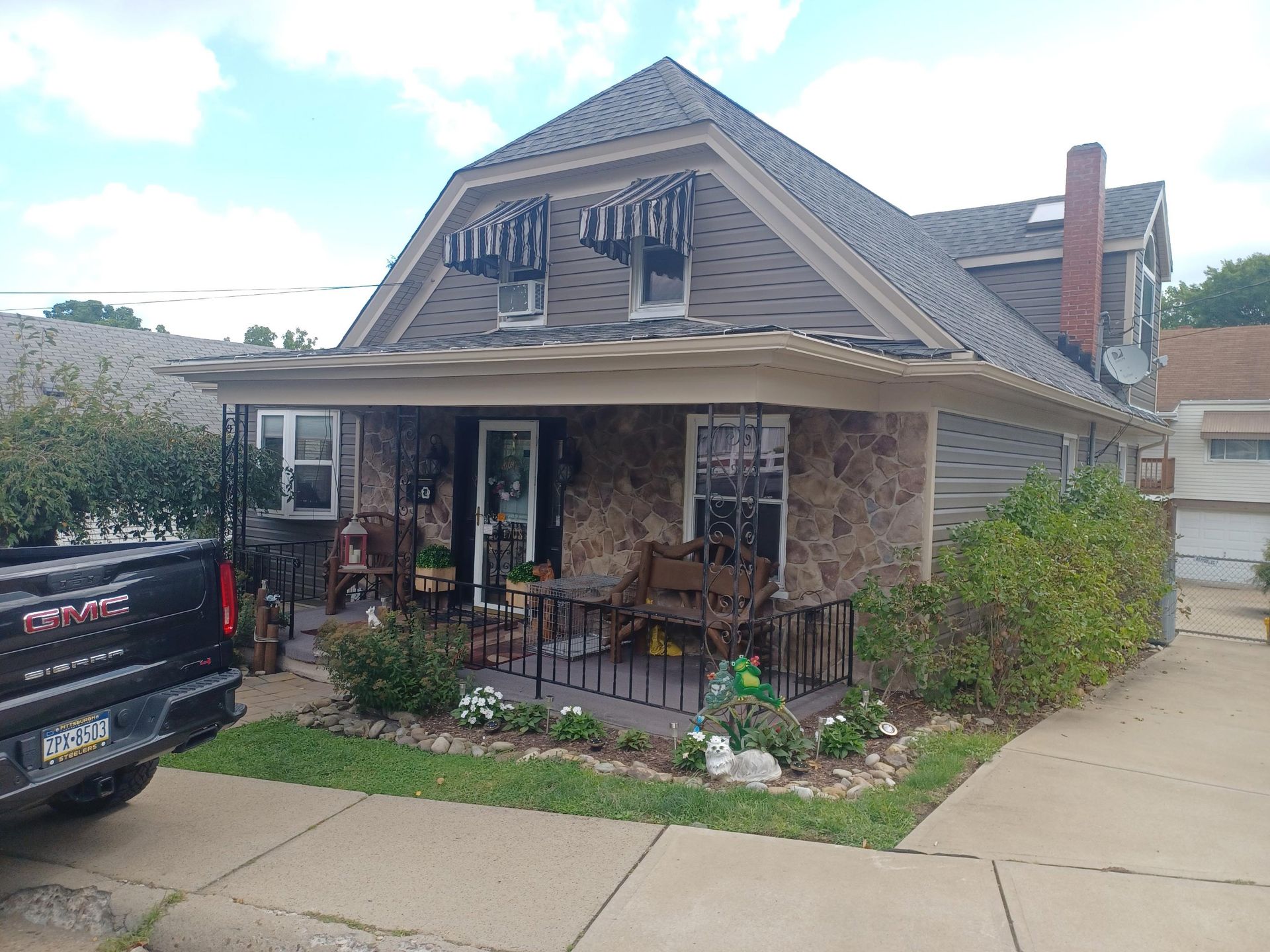 A truck is parked in front of a house with a porch — Window Installation in Lower Burrell, PA